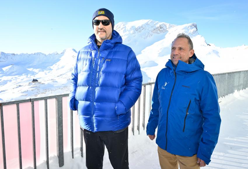 Bayerns Ministerpräsident Dr. Markus Söder (li.) und Umweltminister Thorsten Glauber stehen zusammen am Schneefernerhaus, im Hintergrund schneebedeckte Berge.