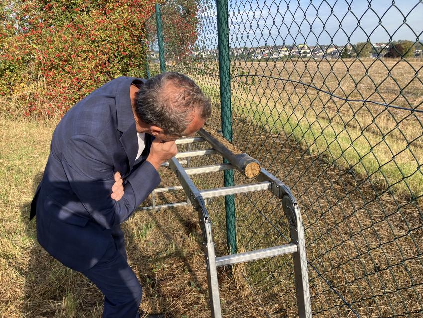 Umweltminister Thorsten Glauber schaut sich eine Bodenprobe  genauer an