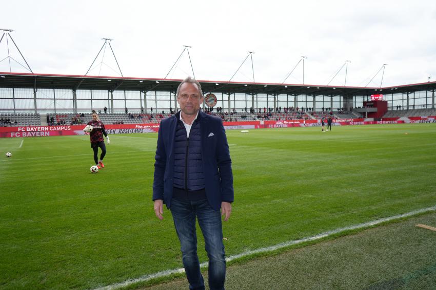 Umweltminister Thorsten Glauber steht am Spielfeld des FC Bayern Campus.