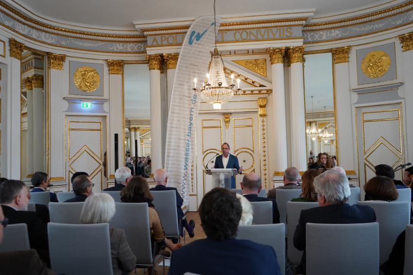 Umweltminister Thorsten Glauber steht am Rednerpult und hält seine Rede zur offiziellen Amtsübergabe der Behördenleitung am Wasserwirtschaftsamt Regensburg. 
