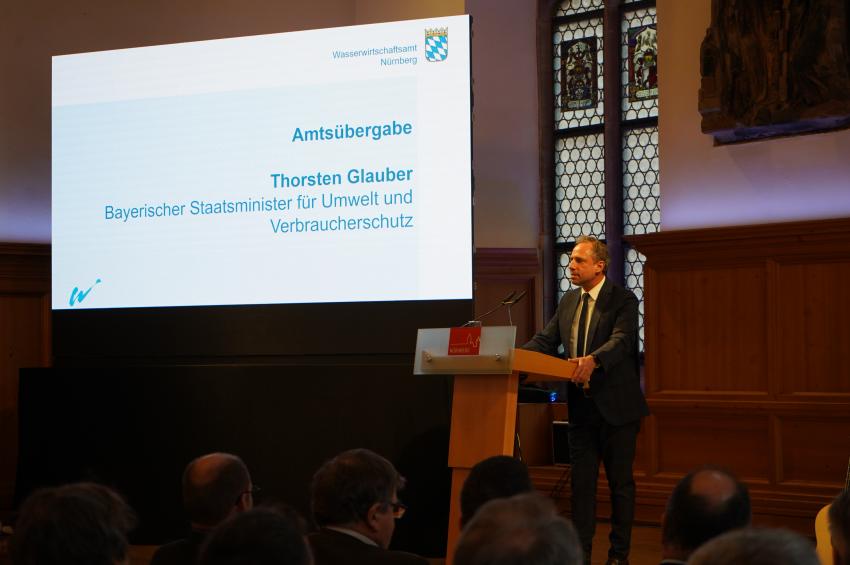 Umweltminister Thorsten Glauber steht am Rednerpult und hält ein Grußwort.