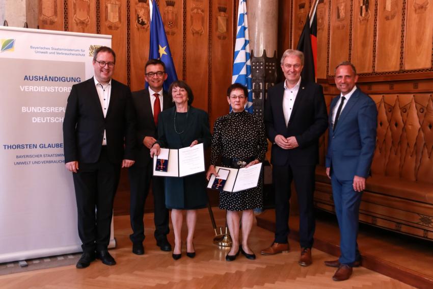 Gruppenfoto zeigt Umweltminister Thorsten Glauber (re) zusammen mit den Ordensträgerinnen Rosa Hentschel und Margareta Spranger, sie zeigen die Verleihungsurkunde mit dem  Bundesverdienstkreuz in die Kamera, und weiteren geladenen Gästen. ©Foto Benjamin Böhm