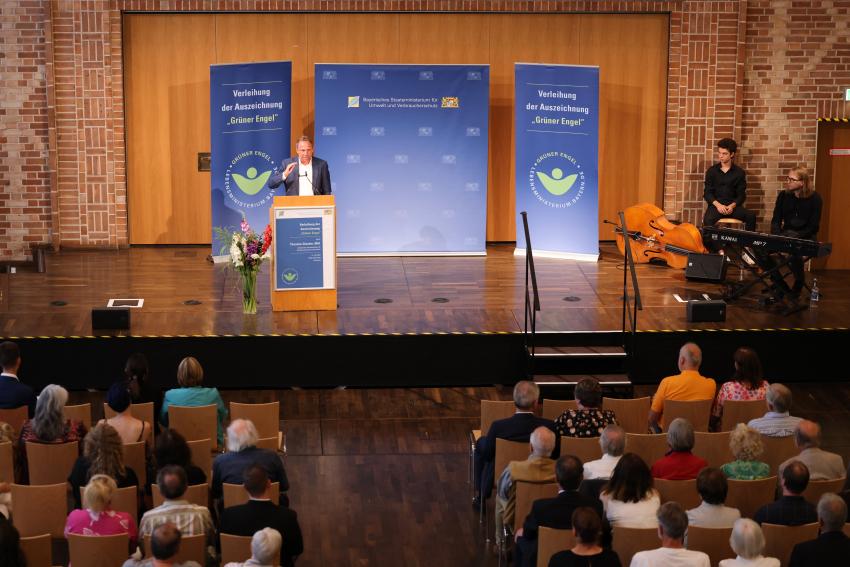  Blick vom Publikum auf Bühne mit Umweltminister Thorsten Glauber am Rednerpult