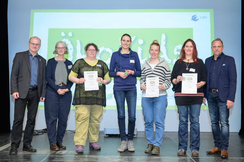 Umweltminister Thorsten Glauber (r.) und Norbert Schäffer, Vorsitzender des Landesbund für Vogelschutz in Bayern e.V. (l.) überreichen die Auszeichnungsurkunden ÖkoKids an die Kitas, von links: Haus für Kinder Hirschgarten München, Ev. Kinderhaus Arche Noah mit Integration Bad Abbach und Montessori Kinderhaus Waldgruppe Wertingen. Carmen Günnewig v. LBV unterstützt als Projektleitung das Projekt ÖkoKids (2. v. l.).