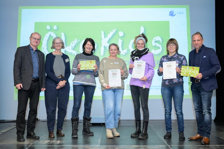 Umweltminister Thorsten Glauber (l.) und Norbert Schäffer, Vorsitzender des Landesbund für Vogelschutz in Bayern e.V. (r.) überreichen die Auszeichnungsurkunden ÖkoKids an die Kitas, von links: Kindergarten St. Martin in Freudenberg, Städt. Haus Naabstraße Regensburg und Waldkindergarten Ammermühle in Bad Kötzting. Carmen Günnewig v. LBV unterstützt als Projektleitung das Projekt ÖkoKids (2. v. li.).