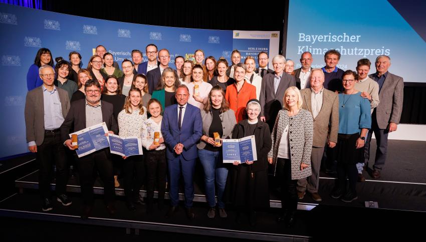 Das Gruppenfoto zeigt den Bayerischen Umweltminister Thorsten Glauber mit den Preisträgern des Bayerischen Klimaschutzpreises 2024 und weitere Gäste.