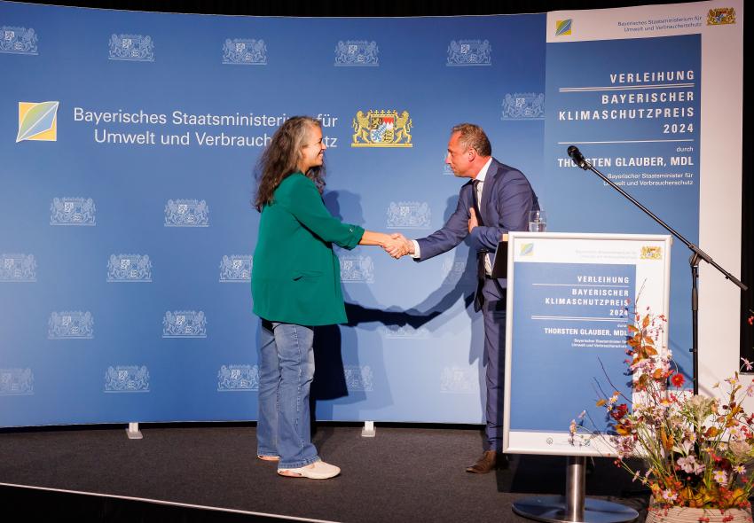 Umweltminister Thorsten Glauber gratuliert der Vertreterin von Community Kitchen gGmbH (München).