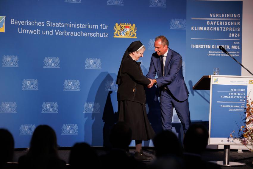 Umweltminister Thorsten Glauber gratuliert der Vertreterin der Kongregation der Schwestern des Erlösers in Würzburg.
