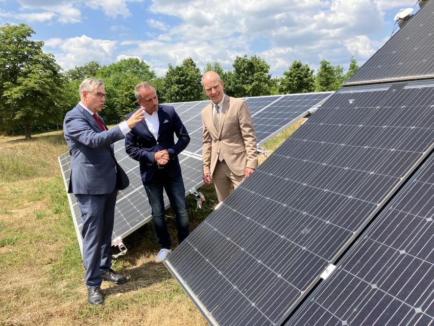 von links: Dr. Hans-Peter Ebert (CAE Geschäftsführender Vorstandsvorsitzender), Umweltminister Thorsten Glauber und Prof. Dr. Jürgen Hartmann (CAE Vorstand und wissenschaftlicher Leiter) stehen zwischen Photovoltaikmodule.