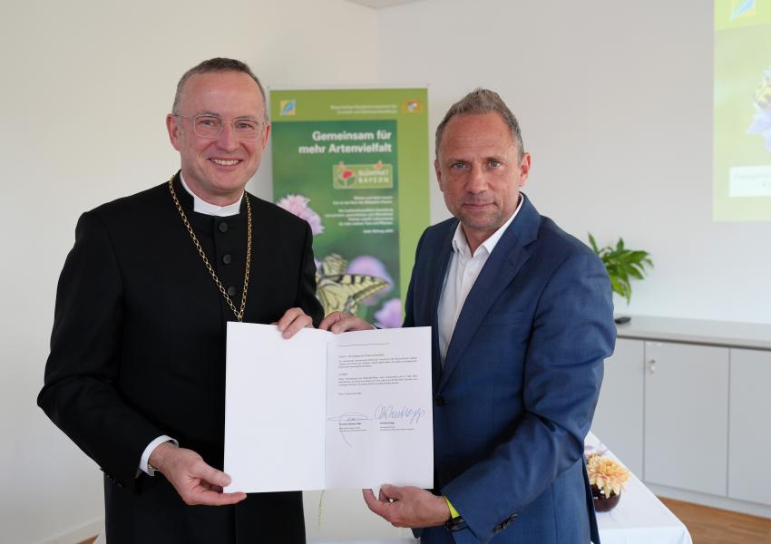 Landesbischof Christian Kopp und Staatsminister Thorsten Glauber präsentieren die unterschriebene Allianz-Vereinbarung. 
