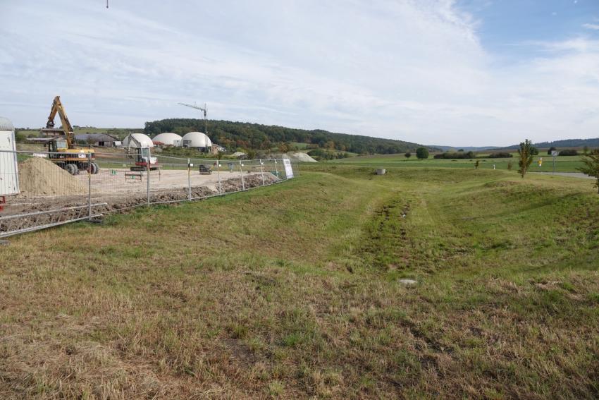 Ansicht der Teilfläche 2 im Oktober 2023 vor der Maßnahmenumsetzung. Entlang der Böschung des Regenrückhaltebeckens sollten heimische Gehölze gepflanzt werden.