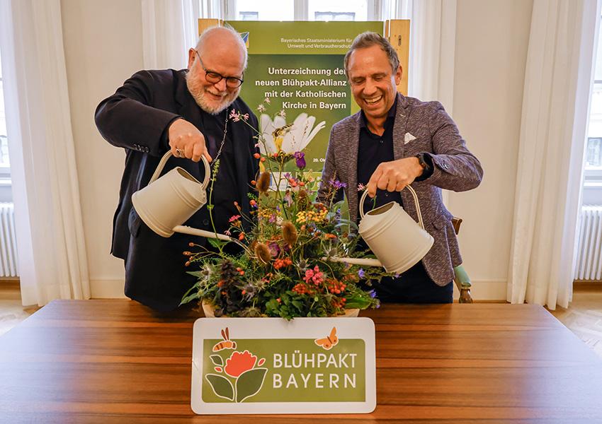 Reinhard Kardinal Marx und Staatsminister Thorsten Glauber gießen eine Schale mit heimischen Wildstauden als Symbol für die Bedeutung von Wasser für die Schöpfung