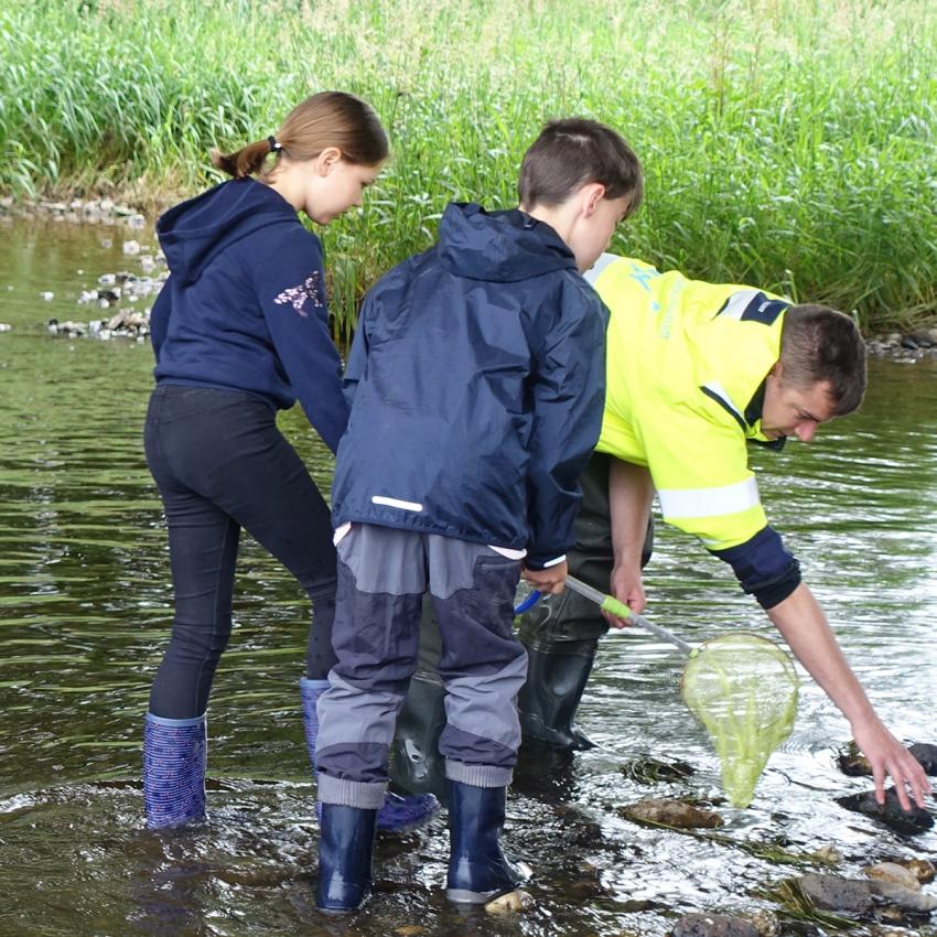 Mädchen und Junge untersuchen zusammen mit einem Mitarbeiter des Wasserwirtschaftsamts Weiden die Gewässerbiologie, Foto: Wasserwirtschaftsamt Weiden
