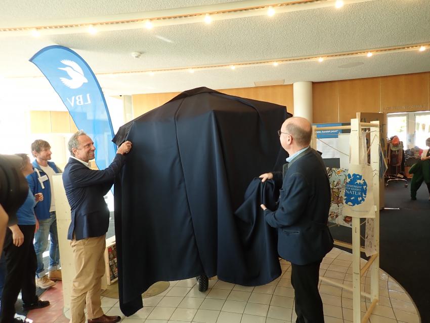 Umweltminister Thorsten Glauber enthüllt zusammen mit LBV-Vorsitzender Dr. Norbert Schäfer den neuen Präsentationsstand für den LBV.