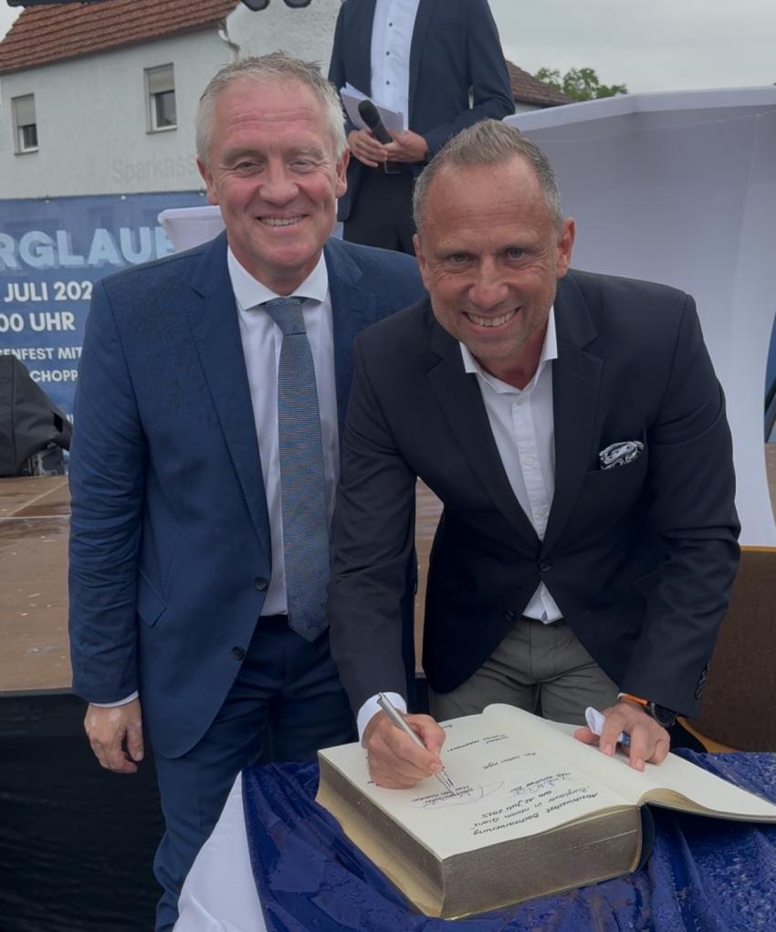 Minister Glauber trägt sich ins Buch ein 