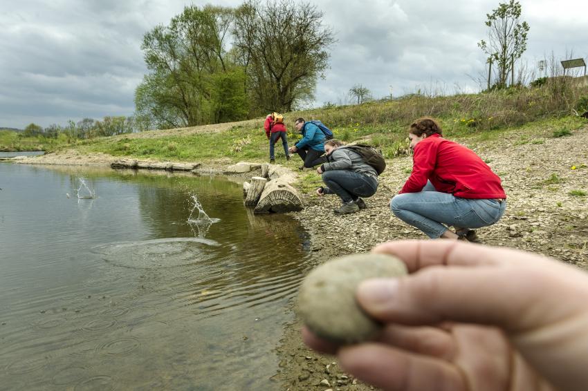 Auf Kiesstrand am Flussufer aufgebautes Fluss-Quiz mit verschiedenen Objekten (Urheber: Andreas Hub/Flussparadies Franken)