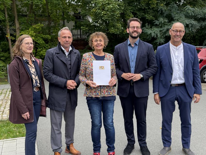 Umweltminister Thorsten Glauber mit Frau Karin Orbes (Mitte), Vorsitzende der Alzheimer Gesellschaft Bayreuth e.V., sowie weitere Vertreterinnen und Vertreter des Cafés, der Stadt Bayreuth und der Regierung