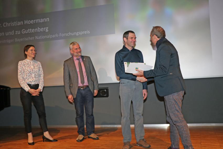 Umweltminister Glauber überreicht an Herrn Dr. von Hoermann von und zu Guttenberg den ersten Forschungspreis der bayerischen Nationalparke für seine wissenschaftliche Arbeit. Links auf der Bühne stehen Nationalparkleiterin Ursula Schuster und Nationalparkleiter Roland Baier.