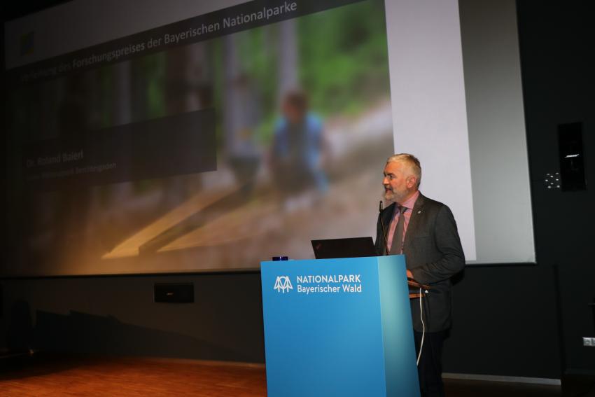 Am Rednerpult steht Dr. Roland Baier, Leiter des Nationalparks Berchtesgaden.