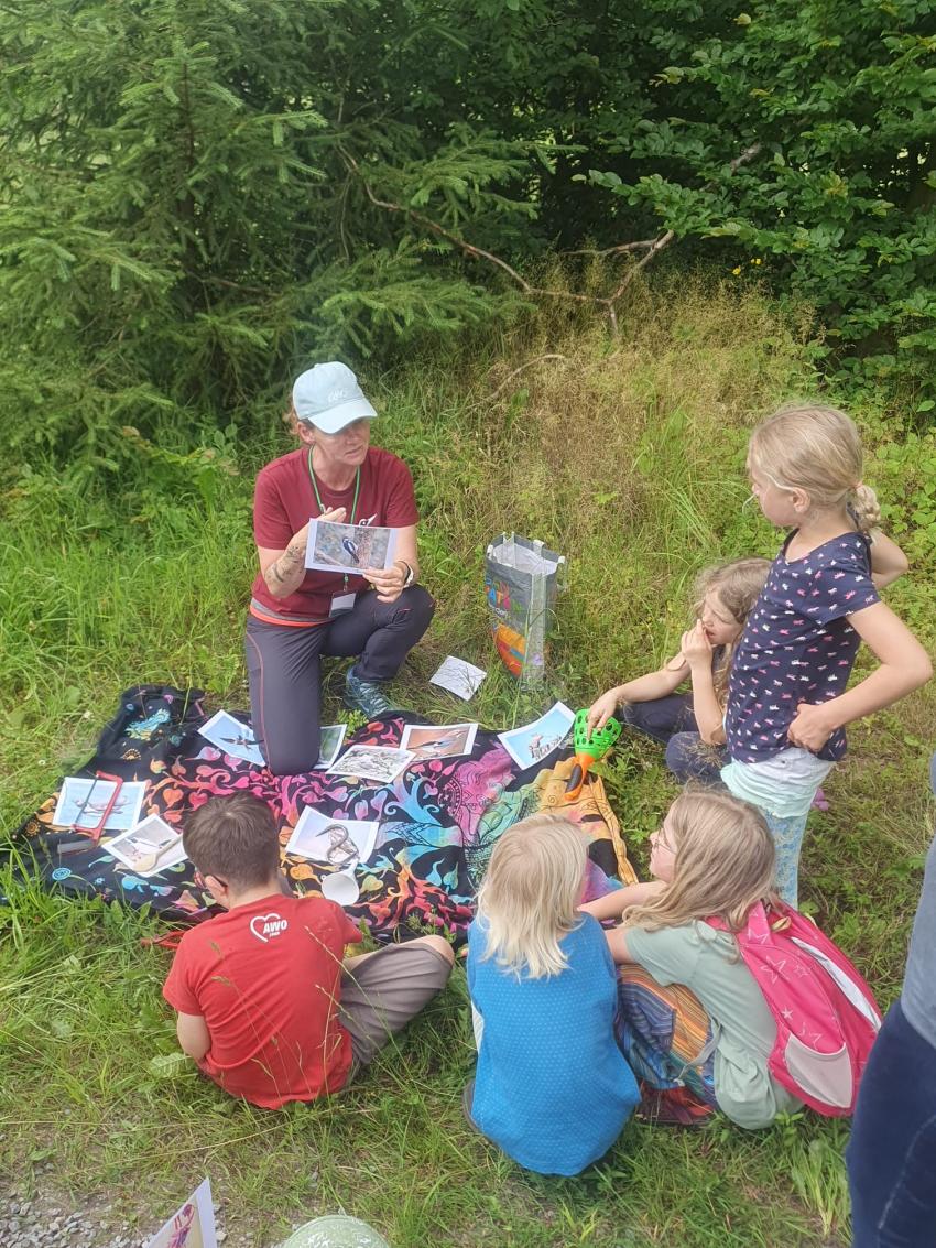 Juliane Wellmann bei einer naturpädagogischen Aktion mit Kindern und Material (Urheberin: Juliane Wellmann)