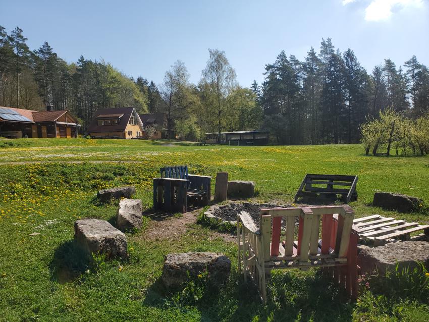 Feuerstelle mit Blick über den Zeltplatz zum Jugendhaus (Urheberin: Bruni Schmidt)