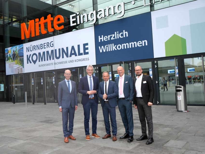 Gruppenfoto mit Umweltminister Thorsten Glauber vor dem Eingang des Messegeländes in Nürnberg, die Kommunale ist eine bundesweite Fachmesse und Kongress für Kommunalbedarf.