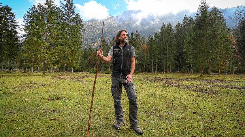 Naturtalent Klaus Melde steht auf einen Stock gestützt im Nationalpark Berchtesgaden.