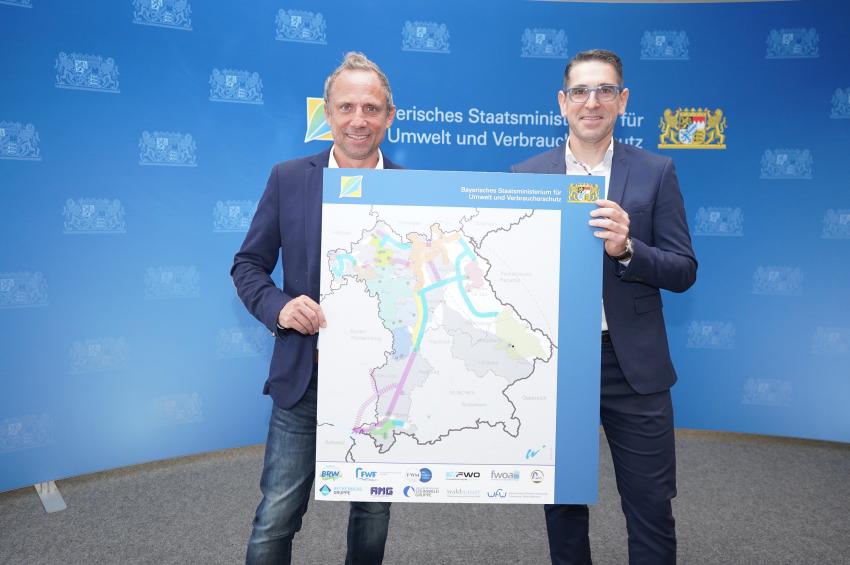 von links: Umweltminister Thorsten Glauber und Dr. Herrmann Löhner, Geschäfts- und Werkleiter der Fernwasserversorgung Franken (FWF) zeigen Karte mit der geplanten Wasserspange.