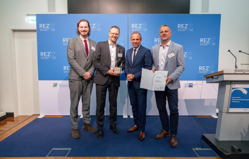 Gruppenfoto zeigt den Preisträger CORDIAL GmbH Sound & Audio Equipment mit Product Manager Stefan Felbermeir, Head of Sales Korbinian Lauxen, Geschäftsführer Wolfgang Schwarz zusammen mit Umweltminister Thorsten Glauber. 