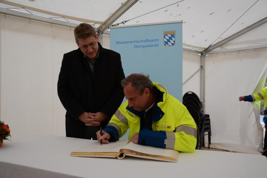 Minister Glauber trägt sich in das Buch ein 