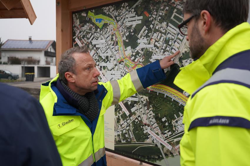 Bayerns Umweltminister Thorsten Glauber vor einer Informationstafel zum Hochwasserausbau in Simbach am Inn
