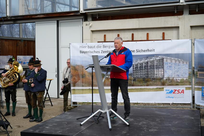 Am Rednerpult steht Thomas Lobensteiner, Vorsitzender der Bergwacht Bayern.