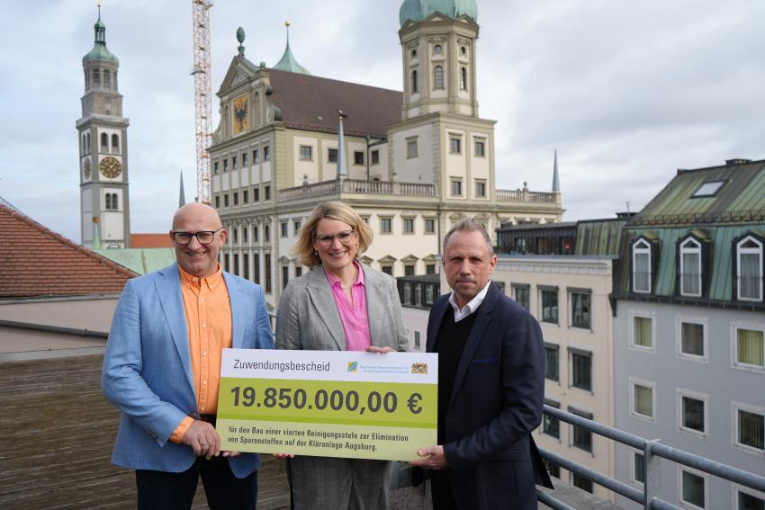 Umweltminister Thorsten Glauber, Oberbürgermeisterin Stadt Augsburg Eva Weber und MdL Anton Rittel zeigen den Zuwendungsscheck für den Bau der 4. Reinigungsstufe.