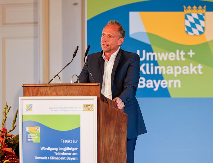 Umweltminister Thorsten Glauber steht am Rednerpult und hält eine Festrede.