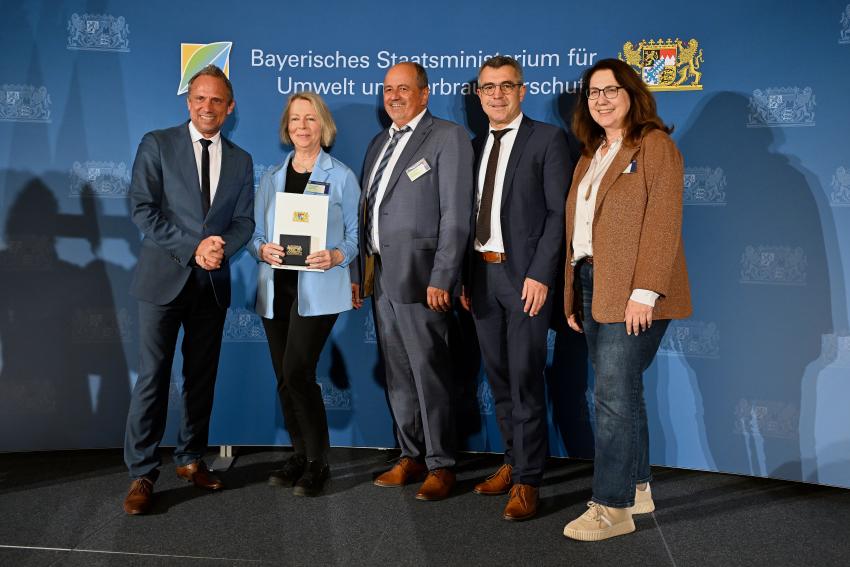 Gruppenfoto zeigt Umweltminister Thorsten Glauber mit der Preisträgerin Christine Schneider, Werner Schneider (Bürgermeister a. D. der Gemeinde Großmehring) und weiteren Gästen.