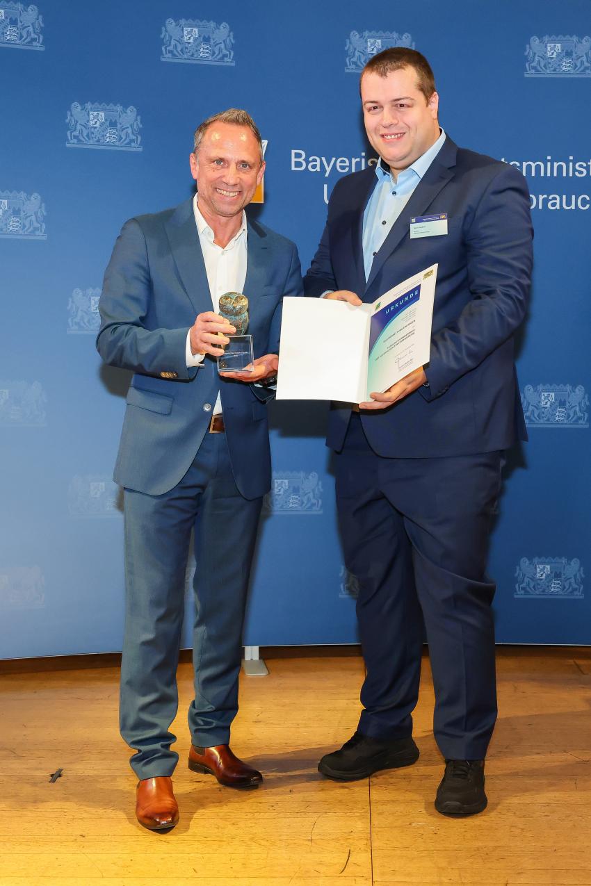 Das Foto zeigt den Bayerischen Umweltminister Thorsten Glauber mit einem Vertreter der Wildtierrettung Erlangen, die Auszeichnungsurkunde und den Tierschutzpreis.
