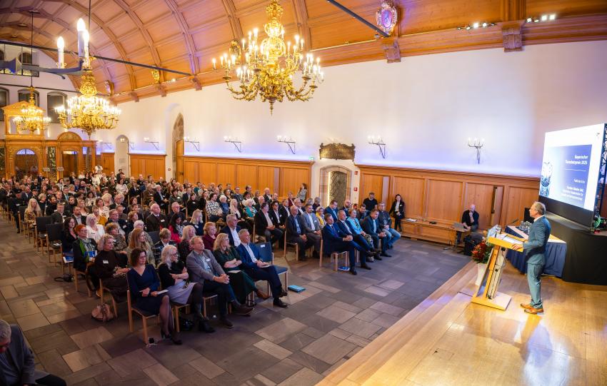 Umweltminister Thorsten Glauber steht am Rednerpult, Blick in den historischen Rathaussaal.