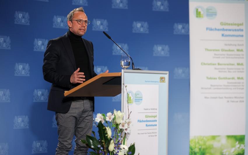 Am Rednerpult steht Thorsten Glauber, Bayerns Staatsminister für Umwelt- und Verbraucherschutz.
