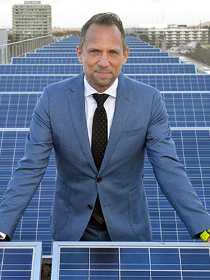 Umweltminister Thorsten Glauber steht zwischen den Solarpanels auf dem Dach des Umweltministeriums