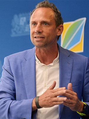 Umweltminister Thorsten Glauber spricht vor blauem Hintergrund und Logo des Umweltministeriums