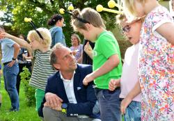 Staatsminister Thorsten Glauber inmitten von Kindern, die Bienenfühlerchen tragen