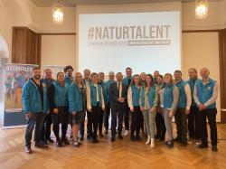 Staatsminister Thorsten Glauber steht inmitten einer Gruppe von Mitarbeitenden der Naturschutzverwaltung, die mit den blauen Jacken der Verwaltung gekleidet sind.