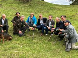 Eine Gruppe von Männern sitz auf einer Wiese.