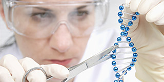 Symbolbild für die Anwendung von Genscheren: Forscherin schneidet mit einer Schere ein Stück aus einem DNA-Strang