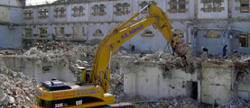 Altlastenbewältigung, Flächenrecycling - Das Bild zeigt einen Bagger, der ein Haus abreißt