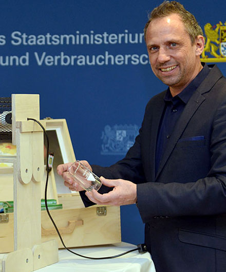 Das Bild zeigt Umweltminister Glauber beim Experimentieren mit einem Klimakoffer