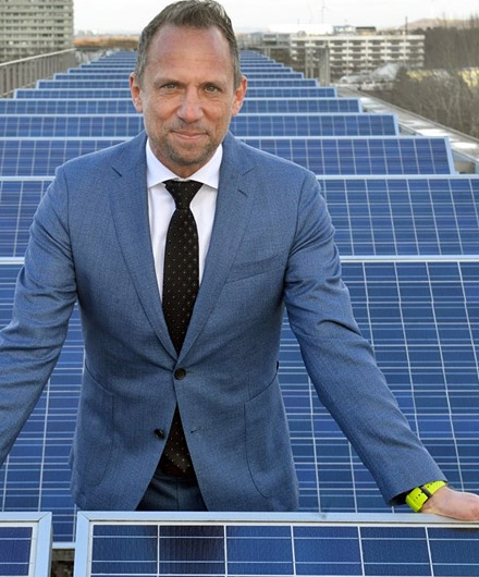 Das Bild zeigt Umweltminister Glauber vor Solarpanels auf dem Dach des Ministeriums