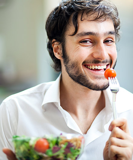 Das Bild zeigt einen Mann der Salat isst
