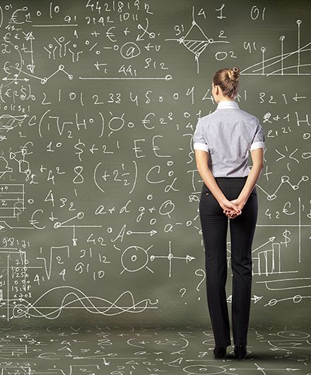 Das Bild zeigt eine Frau vor einer Tafel mit Formeln