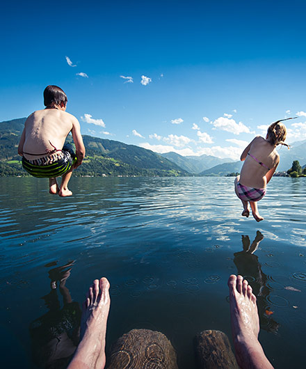 Das Bild zeigt 2 Kinder die in einen See springen